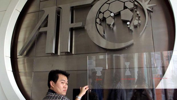 A worker puts finishing touches to the new logo of the Asian Football Confederation (AFC) at their headquarters in Kuala Lumpur, 10 October 2001.  The AFC demanded five automatic berths in the 2006 World Cup as it unveiled a new logo to spur the 