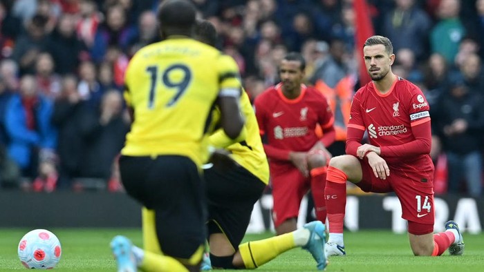 Liverpools English midfielder Jordan Henderson (R) takes a knee in support of the Premier Leagues No Room For Racism campaign ahead of the English Premier League football match between Liverpool and Watford at Anfield in Liverpool, north west England on April 2, 2022. - - RESTRICTED TO EDITORIAL USE. No use with unauthorized audio, video, data, fixture lists, club/league logos or live services. Online in-match use limited to 120 images. An additional 40 images may be used in extra time. No video emulation. Social media in-match use limited to 120 images. An additional 40 images may be used in extra time. No use in betting publications, games or single club/league/player publications. (Photo by Paul ELLIS / AFP) / RESTRICTED TO EDITORIAL USE. No use with unauthorized audio, video, data, fixture lists, club/league logos or live services. Online in-match use limited to 120 images. An additional 40 images may be used in extra time. No video emulation. Social media in-match use limited to 120 images. An additional 40 images may be used in extra time. No use in betting publications, games or single club/league/player publications. / RESTRICTED TO EDITORIAL USE. No use with unauthorized audio, video, data, fixture lists, club/league logos or live services. Online in-match use limited to 120 images. An additional 40 images may be used in extra time. No video emulation. Social media in-match use limited to 120 images. An additional 40 images may be used in extra time. No use in betting publications, games or single club/league/player publications. (Photo by PAUL ELLIS/AFP via Getty Images)