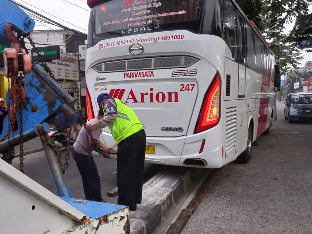 Hindari Pemotor, Bus Pariwisata Tersangkut Separator di Jl M Yusuf Depok