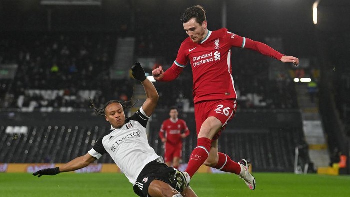 Liverpools Scottish defender Andrew Robertson (R) vies with Fulhams Jamaican striker Bobby Decordova-Reid (L) during the English Premier League football match between Fulham and Liverpool at Craven Cottage in London on December 13, 2020. (Photo by NEIL HALL / POOL / AFP) / RESTRICTED TO EDITORIAL USE. No use with unauthorized audio, video, data, fixture lists, club/league logos or live services. Online in-match use limited to 120 images. An additional 40 images may be used in extra time. No video emulation. Social media in-match use limited to 120 images. An additional 40 images may be used in extra time. No use in betting publications, games or single club/league/player publications. /  (Photo by NEIL HALL/POOL/AFP via Getty Images)