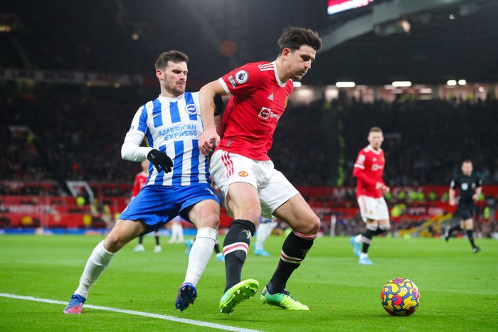 MANCHESTER, ENGLAND - FEBRUARY 15: Harry Maguire of Manchester United battles for possession with Pascal Gross of Brighton during the Premier League match between Manchester United  and  Brighton & Hove Albion at Old Trafford on February 15, 2022 in Manchester, England. (Photo by James Gill - Danehouse/Getty Images)
