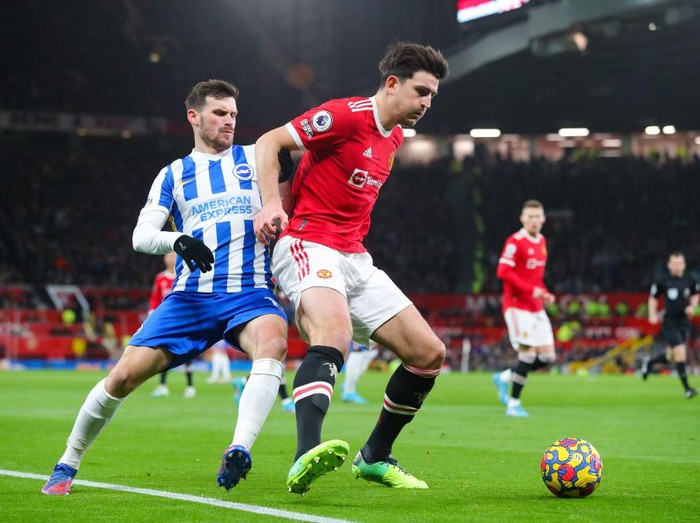 MANCHESTER, ENGLAND - FEBRUARY 15: Harry Maguire of Manchester United battles for possession with Pascal Gross of Brighton during the Premier League match between Manchester United  and  Brighton & Hove Albion at Old Trafford on February 15, 2022 in Manchester, England. (Photo by James Gill - Danehouse/Getty Images)