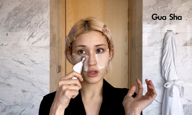Langkah berikutnya adalah dengan memijat wajah menggunakan gua sha/ Foto: Channel Youtube Vogue Untuk mengempiskan wajah bengkaknya karena gemar makan makanan asin, So Mi menggunakan gua sha, alat pijat wajah yang punya beragam lengkungan