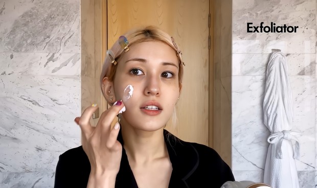 Langkah selanjutnya adalah menggunakan face polish sebagai exfoliator/ Foto: Channel Youtube Vogue Untuk meredakan bengkak pada wajahnya, So Mi menggunakan face polisher yang merupakan produk exfoliator