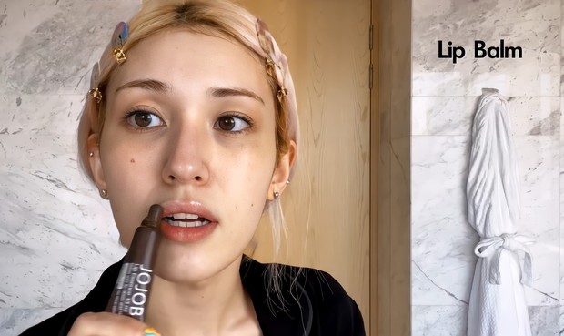 Langkah terakhir adalah mengaplikasikan lip balm pada bibir/ Foto: Channel Youtube Vogue Mengakhiri morning skincare routine, So Mi mengenakan lip balm sebagai penutup