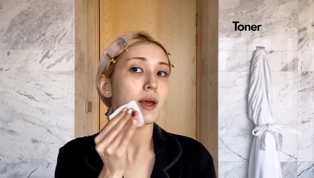 Setelah mengenakan sheet mask dan menggunakan gua sha, So Mi memakai toner/ Foto: Channel Youtube Vogue Langkah selanjutnya untuk morning skincare routine So Mi adalah dengan menggunakan toner dari Cosrx