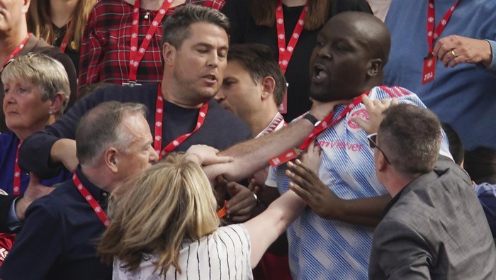 Fans MU Fans fight on the tribune during the English Premier League soccer match between Manchester United and Brighton at Old Trafford stadium in Manchester, England, Sunday, Aug. 7, 2022. (AP Photo/Dave Thompson)