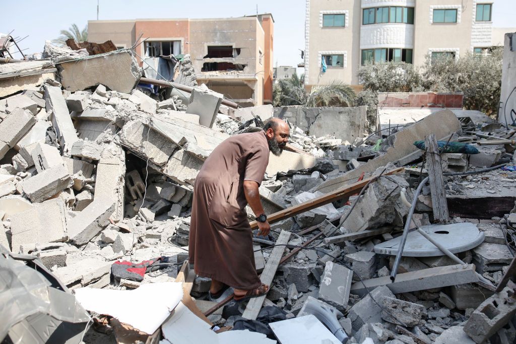 A Palestinian man on the rubble of house destroyed by Israeli airstrikes, in Gaza City, on 06 August 2022. (Photo by Sameh Rahmi/NurPhoto via Getty Images)