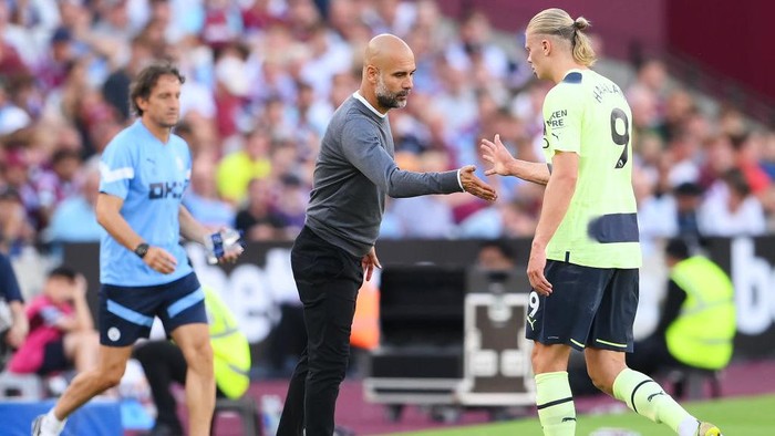 LONDON, ENGLAND - AUGUST 07: Pep Guardiola, Manager of Manchester City interacts with Erling Haaland as they are substituted during the Premier League match between West Ham United and Manchester City at London Stadium on August 07, 2022 in London, England. (Photo by Mike Hewitt/Getty Images)