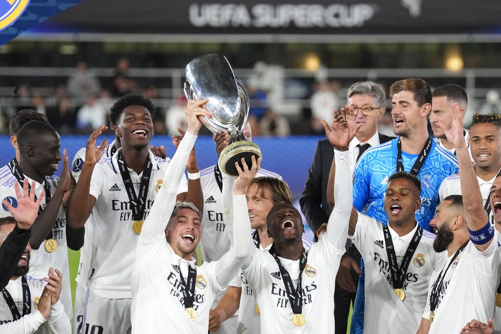 Real Madrid's Federico Valverde, left, and Real Madrid's Eduardo Camavinga lift the trophy after winning the UEFA Super Cup final soccer match between Real Madrid and Eintracht Frankfurt at Helsinki's Olympic Stadium, Finland, Wednesday, Aug. 10, 2022. Real Madrid won 2-0. (AP Photo/Antonio Calanni)