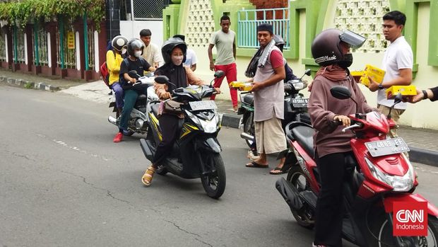 Sejumlah pemain Timnas Indonesia U-16 dan ofisial membagikan makanan kecil usai solat Jumat di Masjid Al-Mujahidin, Sleman, Jumat (12/8).