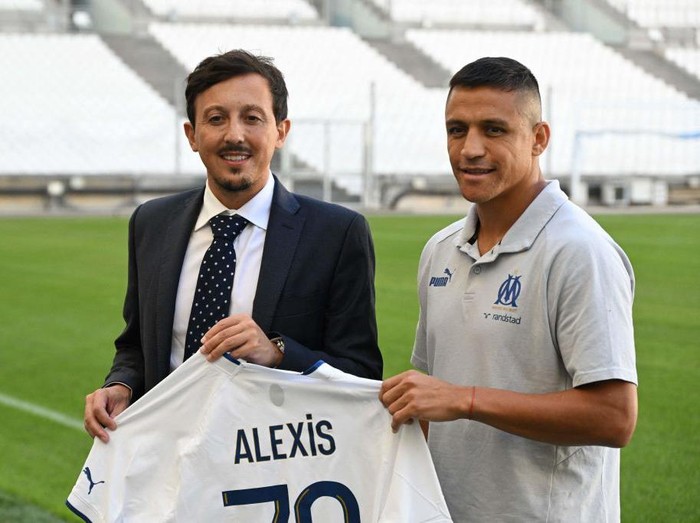 Marseilles Chilean forward Alexis Sanchez (R) poses next to Marseilles Spanish sports director Javier Ribalta (L) after the Olympique de Marseille (OM) announced his signing, at Stade Velodrome in Marseille, southern France, on August 10, 2022. - Marseille has announced on August 10, 2022 the signing of Chilean forward Alexis Sanchez, who has played for Barcelona, Arsenal and Inter Milan, and who will bring his talent, goalscoring ability and experience of the highest level to the attack. (Photo by CHRISTOPHE SIMON / AFP) (Photo by CHRISTOPHE SIMON/AFP via Getty Images)