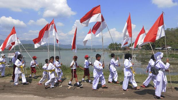 Peserta mengikuti kirab dan pemasangan 77 Bendera Merah Putih di Krakitan, Bayat, Klaten, Jawa Tengah, Minggu (14/8/2022). Sebanyak 77 Bendera Merah Putih dikirabkan dan dipasang di Omah Bendera Wonosegoro yang merupakan rumah salah satu warga setempat yang selalu memasang Bendera Merah Putih sesuai dengan jumlah usia Kemerdekaan Republik Indonesia. ANTARA FOTO/Aloysius Jarot Nugroho.