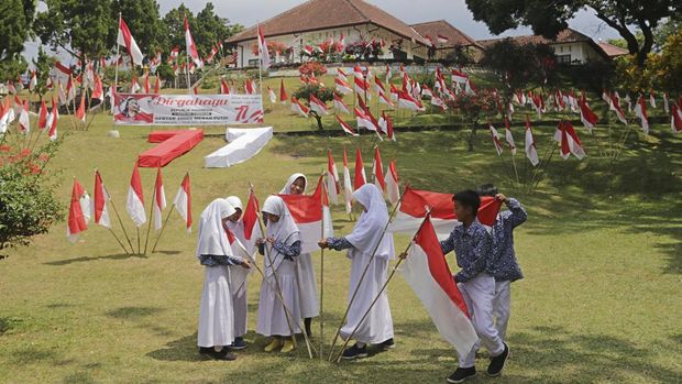 Sejumlah pelajar memasang Bendera Merah Putih di halaman Gedung Perundingan Linggarjati, Kuningan, Jawa Barat, Kamis (11/8/2022). Pemasangan 10.001 Bendera Merah Putih tersebut dalam rangka menyambut perayaan HUT ke-77 Kemerdekaan RI. ANTARA FOTO/Dedhez Anggara/rwa.