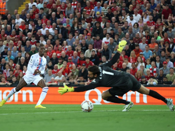 LIVERPOOL, ENGLAND - AUGUST 15: Wilfried Zaha of Crystal Palace scores their team's first goal past Alisson Becker of Liverpool during the Premier League match between Liverpool FC and Crystal Palace at Anfield on August 15, 2022 in Liverpool, England. (Photo by Clive Brunskill/Getty Images)