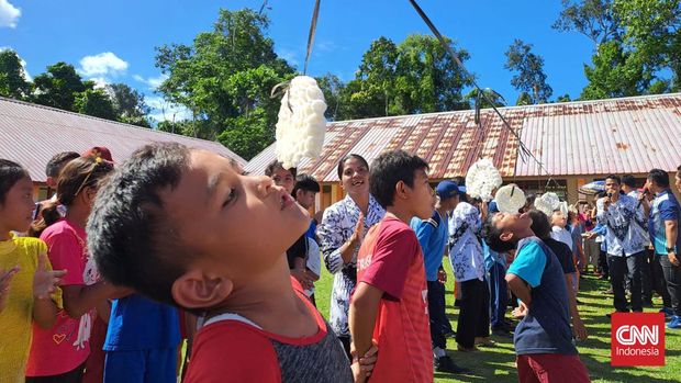 Masyarakat dan anak sekolah merayakan hari kemerdekaan RI ke-77 di halaman Sekolah SMP N 1 Sipora Utara dengan lomba memakan kerupuk, panjat pinang, dll. (CNNIndonesia/Sonya)