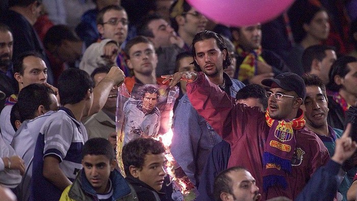 BARCELONA, SPAIN:  Barcelona supporters burn a portrait of Portugese player Luis Figo, 21 October 2000 who left the club for Real Madrid this season, during the 1st divison match of the Spanish championship, Barcelona vs Real Madrid, at the Nou Camp in Barcelona. (Photo credit should read CHRISTOPHE SIMON/AFP via Getty Images)