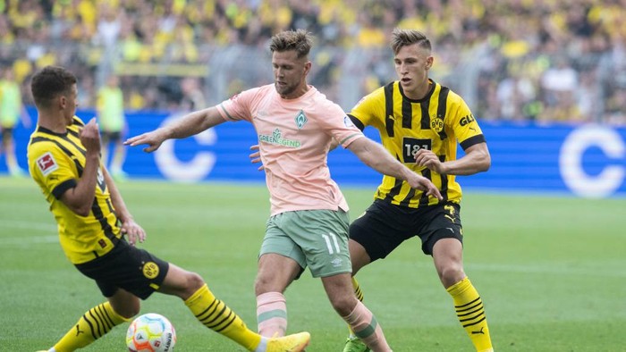 20 August 2022, North Rhine-Westphalia, Dortmund: Soccer: Bundesliga, Borussia Dortmund - Werder Bremen, Matchday 3, Signal Iduna Park. Dortmunds Thorgan Hazard, Dortmunds Nico Schlotterbeck and Bremens Niclas Füllkrug try to get to the ball. Photo: Bernd Thissen/dpa - IMPORTANT NOTE: In accordance with the requirements of the DFL Deutsche Fußball Liga and the DFB Deutscher Fußball-Bund, it is prohibited to use or have used photographs taken in the stadium and/or of the match in the form of sequence pictures and/or video-like photo series. (Photo by Bernd Thissen/picture alliance via Getty Images)