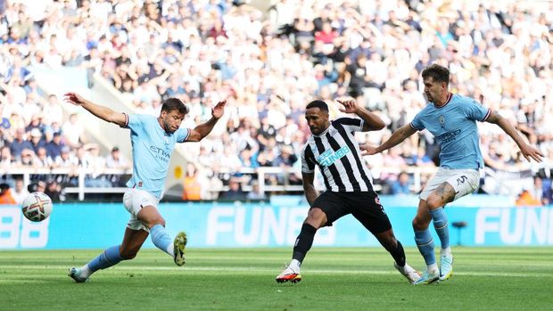 NEWCASTLE UPON TYNE, ENGLAND - AUGUST 21: Callum Wilson of Newcastle United scores their side's second goal whilst under pressure from Joao Cancelo and John Stones of Manchester City during the Premier League match between Newcastle United and Manchester City at St. James Park on August 21, 2022 in Newcastle upon Tyne, England. (Photo by Clive Brunskill/Getty Images)