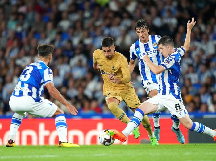 Lewandowski Dua Gol, Barcelona Pecundangi Real Sociedad 4-1 SAN SEBASTIAN, SPAIN - AUGUST 21: Ferran Torres of FC Barcelona battles for possession with Igor Zubeldia of Real Sociedad during the LaLiga Santander match between Real Sociedad and FC Barcelona at Reale Arena on August 21, 2022 in San Sebastian, Spain. (Photo by Juan Manuel Serrano Arce/Getty Images)