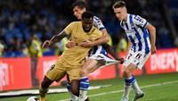 Gelandang Pantai Gading Barcelona Franck Kessie (kiri) berebut bola dengan bek Real Sociedad Prancis Robin Le Normand (tengah). Di sisa waktu, tak ada gol tambahan tercipta. Kemenangan 4-1 Barcelona atas Sociedad tetap bertahan. (Ander Gillenea/AFP/Getty Images)