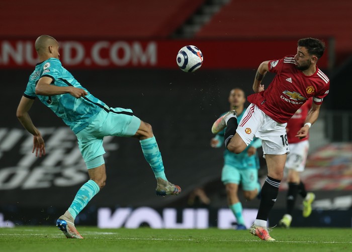MANCHESTER, ENGLAND - MAY 13: Bruno Fernandes of Manchester United in action with Fabinho of Liverpool during the Premier League match between Manchester United and Liverpool at Old Trafford on May 13, 2021 in Manchester, England. Sporting stadiums around the UK remain under strict restrictions due to the Coronavirus Pandemic as Government social distancing laws prohibit fans inside venues resulting in games being played behind closed doors. (Photo by Matthew Peters/Manchester United via Getty Images)