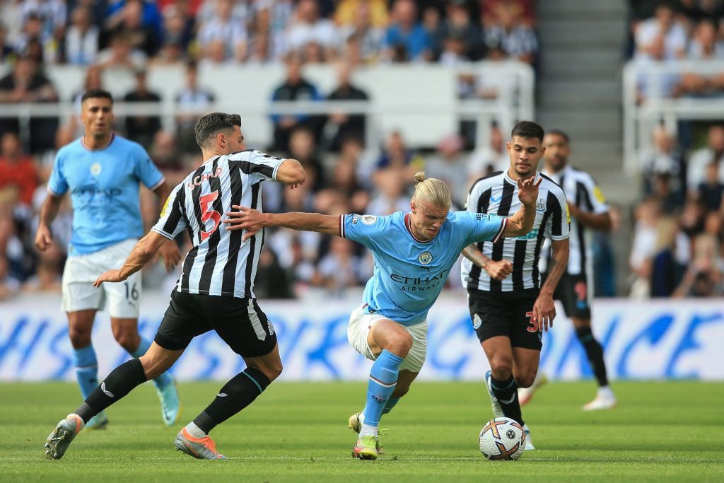 Manchester City's Norwegian striker Erling Haaland (C) runs with the ball past Newcastle United's Swiss defender Fabian Schar (L) during the English Premier League football match between Newcastle United and Manchester City at St James' Park in Newcastle-upon-Tyne, north east England, on August 21, 2022. - RESTRICTED TO EDITORIAL USE. No use with unauthorized audio, video, data, fixture lists, club/league logos or 'live' services. Online in-match use limited to 120 images. An additional 40 images may be used in extra time. No video emulation. Social media in-match use limited to 120 images. An additional 40 images may be used in extra time. No use in betting publications, games or single club/league/player publications. (Photo by Lindsey Parnaby / AFP) / RESTRICTED TO EDITORIAL USE. No use with unauthorized audio, video, data, fixture lists, club/league logos or 'live' services. Online in-match use limited to 120 images. An additional 40 images may be used in extra time. No video emulation. Social media in-match use limited to 120 images. An additional 40 images may be used in extra time. No use in betting publications, games or single club/league/player publications. / RESTRICTED TO EDITORIAL USE. No use with unauthorized audio, video, data, fixture lists, club/league logos or 'live' services. Online in-match use limited to 120 images. An additional 40 images may be used in extra time. No video emulation. Social media in-match use limited to 120 images. An additional 40 images may be used in extra time. No use in betting publications, games or single club/league/player publications. (Photo by LINDSEY PARNABY/AFP via Getty Images)