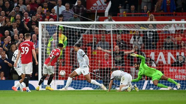 MANCHESTER, ENGLAND - AUGUST 22: Jadon Sancho of Manchester United scores their side's first goal past Alisson Becker of Liverpool  during the Premier League match between Manchester United and Liverpool FC at Old Trafford on August 22, 2022 in Manchester, England. (Photo by Michael Regan/Getty Images)