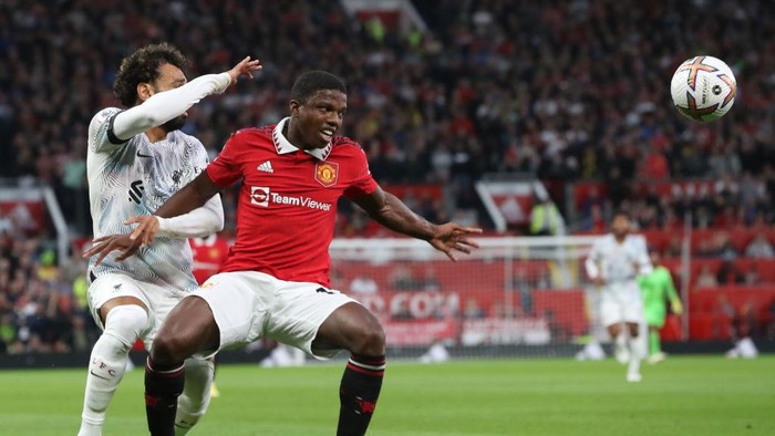 MANCHESTER, ENGLAND - AUGUST 22: Tyrell Malacia of Manchester United in action with Mohamed Salah of Liverpool during the Premier League match between Manchester United and Liverpool FC at Old Trafford on August 22, 2022 in Manchester, England. (Photo by Tom Purslow/Manchester United via Getty Images)