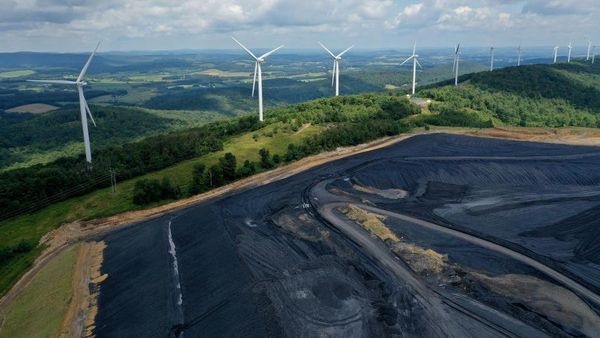 Kontras, Barisan Turbin Angin Ini Bersisian dengan Onggokan Batu Bara