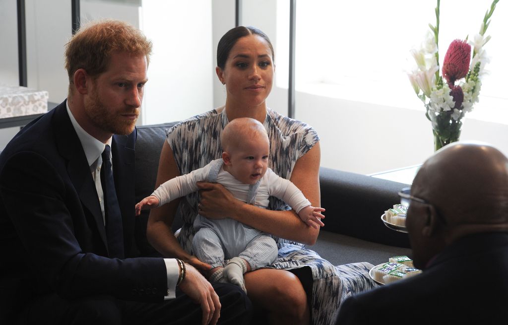Britain's Duke and Duchess of Sussex, Prince Harry and his wife Meghan hold their baby son Archie as they meet with Archbishop Desmond Tutu at the Tutu Legacy Foundation  in Cape Town on September 25, 2019. - The British royal couple are on a 10-day tour of southern Africa -- their first official visit as a family since their son Archie was born in May. (Photo by HENK KRUGER / POOL / AFP)        (Photo credit should read HENK KRUGER/AFP via Getty Images)