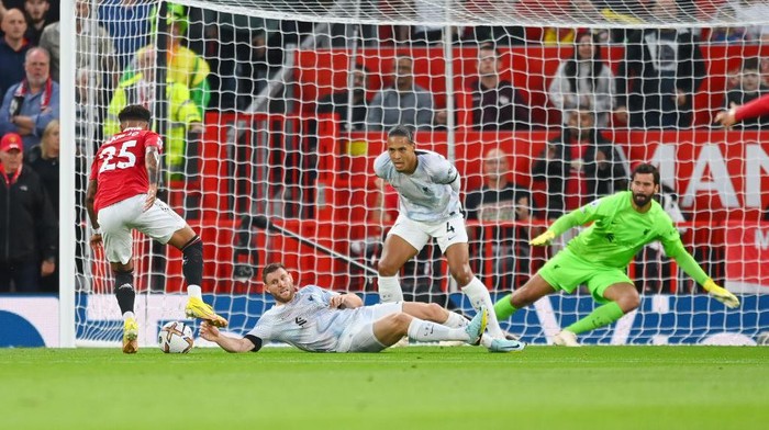 MANCHESTER, ENGLAND - AUGUST 22: Jadon Sancho of Manchester United sells a dummy to James Milner and Virgil van Dijk before scoring to make it 1-0 during the Premier League match between Manchester United and Liverpool FC at Old Trafford on August 22, 2022 in Manchester, England. (Photo by Michael Regan/Getty Images)