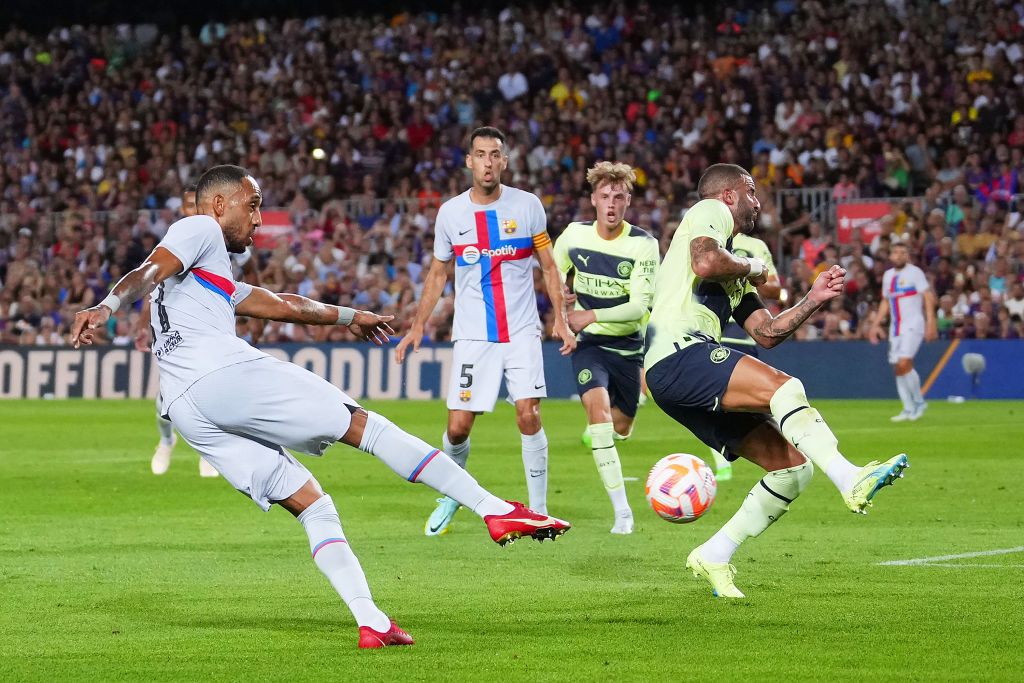 BARCELONA, SPAIN - AUGUST 24: Pierre-Emerick Aubameyang of FC Barcelona scores their team's first goal while under pressure from Kyle Walker of Manchester City during the friendly match between FC Barcelona and Manchester City at Camp Nou on August 24, 2022 in Barcelona, Spain. (Photo by Alex Caparros/Getty Images)