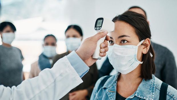 Ilustrasi wanita pakai masker diperiksa suhu saat pandemi COVID-19