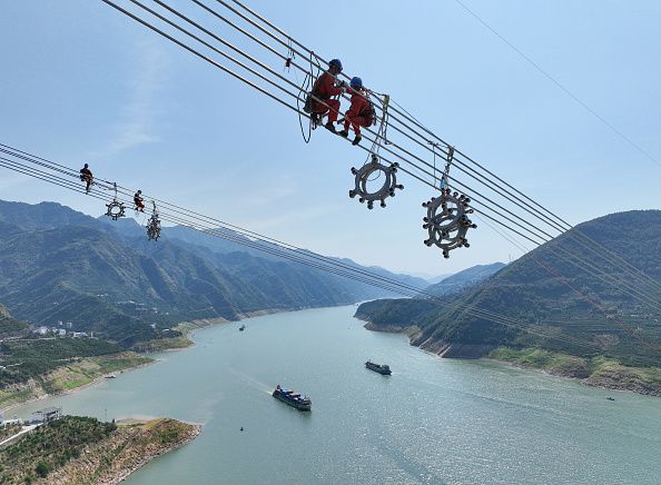 YICHANG, CHINA - AUGUST 25, 2022 - Aerial photo taken on Aug 25, 2022 shows workers installing spacers across the Yangtze River on the ultra-high voltage 