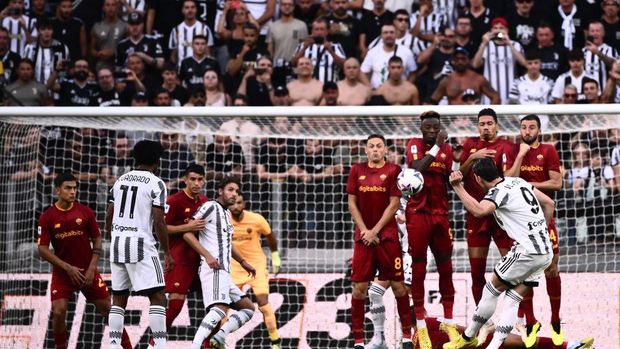 Juventus' Serbian forward Dusan Vlahovic (R) shoots a free kick to open the scoring during the Italian Serie A football match between Juventus and AS Roma on August 27, 2022 at the Juventus stadium in Turin. (Photo by Marco BERTORELLO / AFP) (Photo by MARCO BERTORELLO/AFP via Getty Images)
