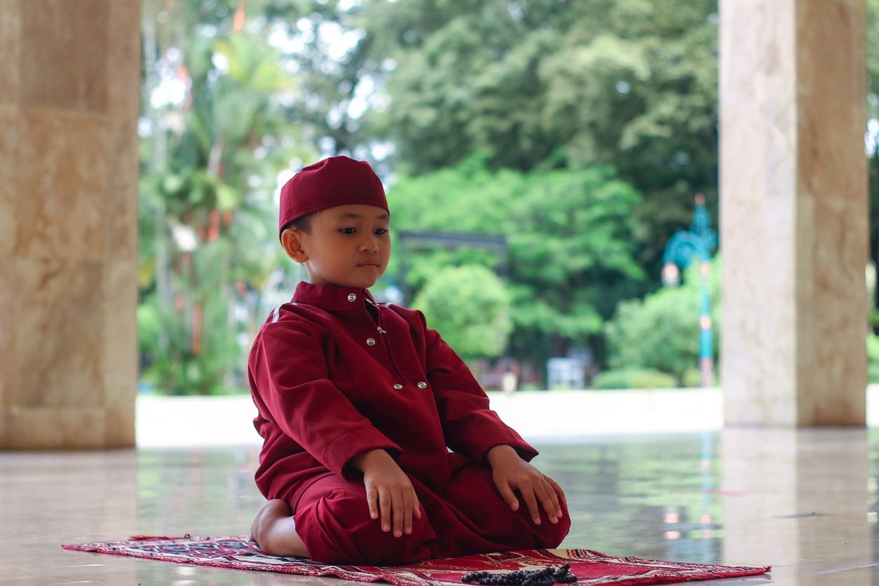 Asian Muslim boy at mosque praying