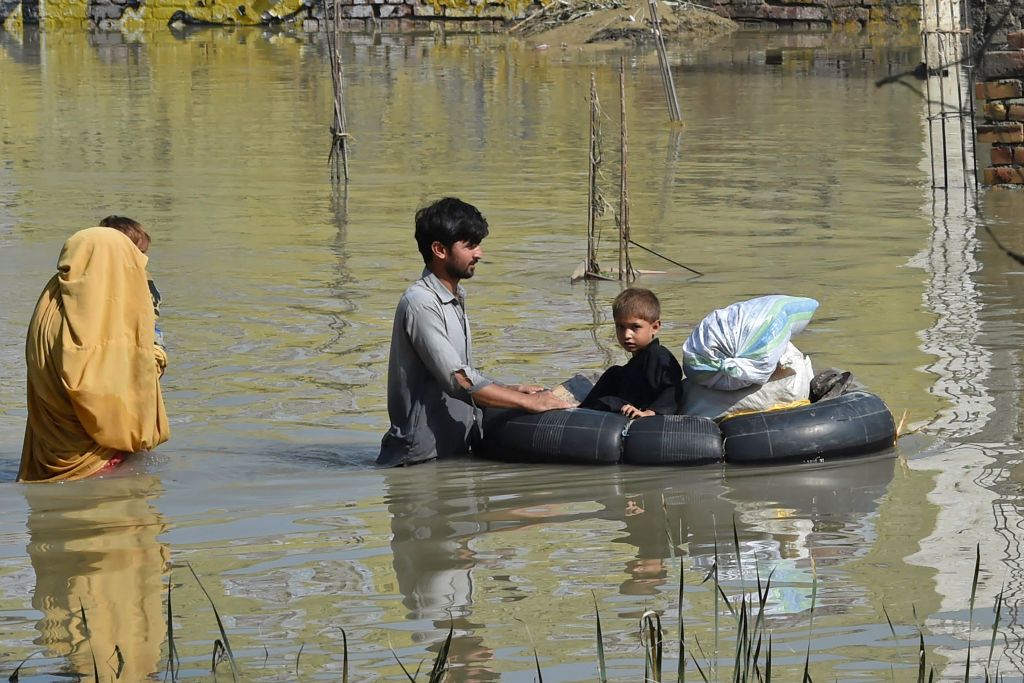 CHARSADDA, PAKISTAN - AUGUST 28: A man is seen trying to survive at a flooded area in Charsadda, Khyber Pakhtunkhwa province, Pakistan on August 28, 2022. Flash floods triggered by destructive monsoon rains have killed more than 1,000 people and injured thousands more since June. Pakistan is appealing for further international assistance while the government has declared an emergency to deal with the serious climate catastrophe that devastated the country. (Photo by Hussain Ali/Anadolu Agency via Getty Images)
