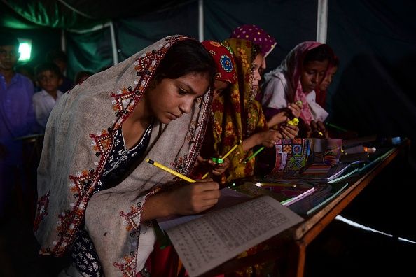Flood-affected children attend a class at a makeshift school run by the Charity Al-Khidmat Foundation in Sukkur, Sindh province, on September 1, 2022. - Monsoon rains have submerged a third of Pakistan, claiming at least 1,190 lives since June and unleashing powerful floods that have washed away swathes of vital crops and damaged or destroyed more than a million homes. (Photo by Asif HASSAN / AFP) (Photo by ASIF HASSAN/AFP via Getty Images)