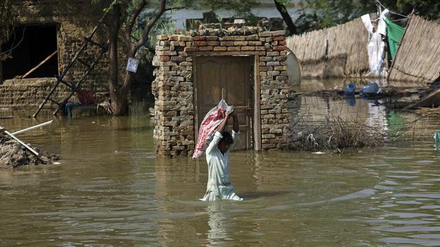 FILE - A man carries supplies rescued from his home after floods hit the flood-hit Shikarpur district of Sindh province, Pakistan, Wednesday, August 31, 2022. The United Nations Meteorological Agency La Nina forecast is about to hit.  which will last until the end of this year, something amazing 