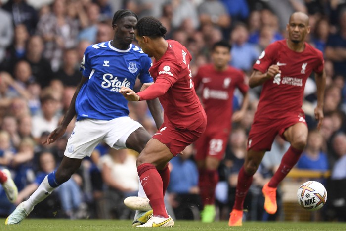 Liverpools Dutch defender Virgil van Dijk (C) is booked for this foul on Evertons Senegalese-born Belgian midfielder Amadou Onana (L) during the English Premier League football match between Everton and Liverpool at Goodison Park in Liverpool, north west England on September 3, 2022. - RESTRICTED TO EDITORIAL USE. No use with unauthorized audio, video, data, fixture lists, club/league logos or live services. Online in-match use limited to 120 images. An additional 40 images may be used in extra time. No video emulation. Social media in-match use limited to 120 images. An additional 40 images may be used in extra time. No use in betting publications, games or single club/league/player publications. (Photo by Oli SCARFF / AFP) / RESTRICTED TO EDITORIAL USE. No use with unauthorized audio, video, data, fixture lists, club/league logos or live services. Online in-match use limited to 120 images. An additional 40 images may be used in extra time. No video emulation. Social media in-match use limited to 120 images. An additional 40 images may be used in extra time. No use in betting publications, games or single club/league/player publications. / RESTRICTED TO EDITORIAL USE. No use with unauthorized audio, video, data, fixture lists, club/league logos or live services. Online in-match use limited to 120 images. An additional 40 images may be used in extra time. No video emulation. Social media in-match use limited to 120 images. An additional 40 images may be used in extra time. No use in betting publications, games or single club/league/player publications. (Photo by OLI SCARFF/AFP via Getty Images)