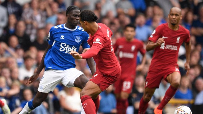 Liverpools Dutch defender Virgil van Dijk (C) is booked for this foul on Evertons Senegalese-born Belgian midfielder Amadou Onana (L) during the English Premier League football match between Everton and Liverpool at Goodison Park in Liverpool, north west England on September 3, 2022. - RESTRICTED TO EDITORIAL USE. No use with unauthorized audio, video, data, fixture lists, club/league logos or live services. Online in-match use limited to 120 images. An additional 40 images may be used in extra time. No video emulation. Social media in-match use limited to 120 images. An additional 40 images may be used in extra time. No use in betting publications, games or single club/league/player publications. (Photo by Oli SCARFF / AFP) / RESTRICTED TO EDITORIAL USE. No use with unauthorized audio, video, data, fixture lists, club/league logos or live services. Online in-match use limited to 120 images. An additional 40 images may be used in extra time. No video emulation. Social media in-match use limited to 120 images. An additional 40 images may be used in extra time. No use in betting publications, games or single club/league/player publications. / RESTRICTED TO EDITORIAL USE. No use with unauthorized audio, video, data, fixture lists, club/league logos or live services. Online in-match use limited to 120 images. An additional 40 images may be used in extra time. No video emulation. Social media in-match use limited to 120 images. An additional 40 images may be used in extra time. No use in betting publications, games or single club/league/player publications. (Photo by OLI SCARFF/AFP via Getty Images)