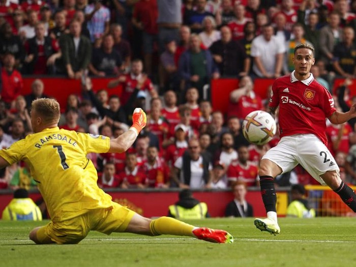 Manchester United's Antony, right, scores his side's opening goal past Arsenal's goalkeeper Aaron Ramsdale during the English Premier League soccer match between Manchester United and Arsenal at Old Trafford stadium, in Manchester, England, Sunday, Sept. 4, 2022. (AP Photo/Dave Thompson)