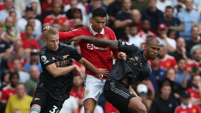 Cristiano Ronaldo MANCHESTER, ENGLAND - SEPTEMBER 04: Cristiano Ronaldo of Manchester United in action with Oleksandr Zinchenko and Gabriel of Arsenal during the Premier League match between Manchester United and Arsenal FC at Old Trafford on September 04, 2022 in Manchester, England. (Photo by Tom Purslow/Manchester United via Getty Images)