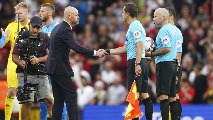 Manchester Uniteds head coach Erik ten Hag shakes hands with referees after the English Premier League soccer match between Manchester United and Arsenal at Old Trafford stadium, in Manchester, England, Sunday, Sept. 4, 2022. (AP Photo/Dave Thompson)