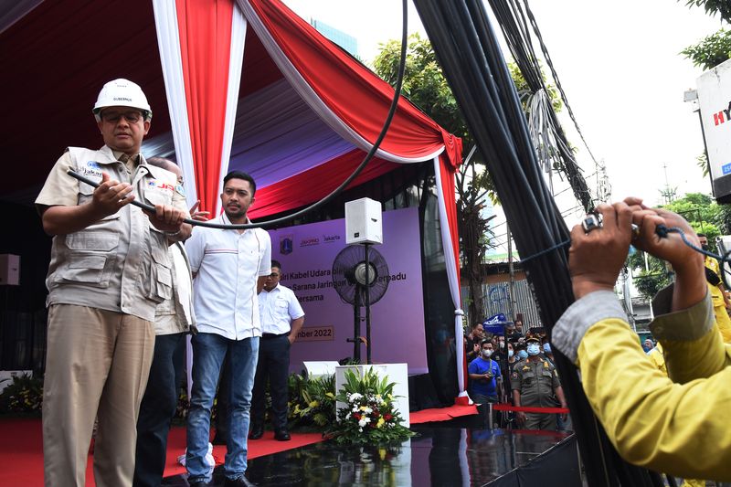 Petugas Bina Marga DKI Jakarta menurunkan kabel utilitas di Pasar Mampang Prapatan, Jakarta, Senin (5/9/2022). Dinas Bina Marga DKI Jakarta menurunkan 58 kabel utilitas dari 39 operator jaringan telekomunikasi di kawasan Mampang Prapatan yang menjuntai di udara untuk dipindahkan ke Sarana Jaringan Utilitas Terpadu (SJUT) di bawah tanah. ANTARA FOTO/Indrianto Eko Suwarso/rwa.