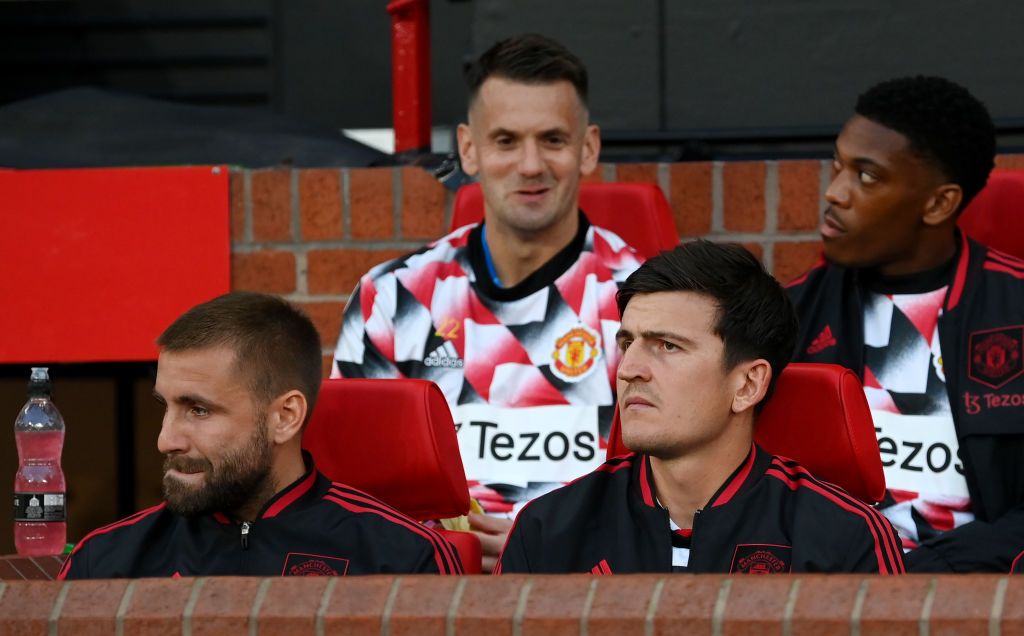 MANCHESTER, ENGLAND - AUGUST 22: Harry Maguire and Luke Shaw of Manchester United look on from the substitutes bench prior to the Premier League match between Manchester United and Liverpool FC at Old Trafford on August 22, 2022 in Manchester, England. (Photo by Michael Regan/Getty Images)