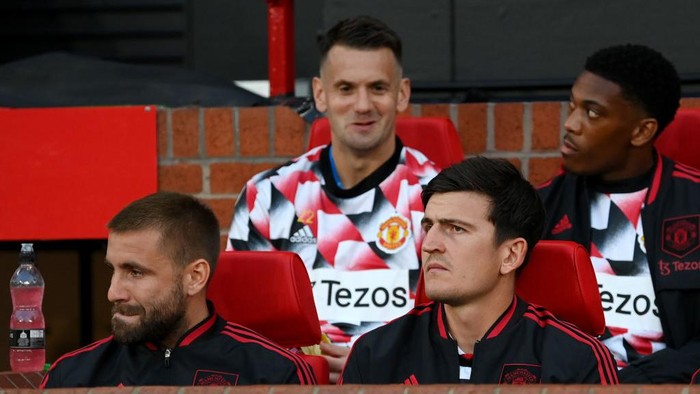 MANCHESTER, ENGLAND - AUGUST 22: Harry Maguire and Luke Shaw of Manchester United look on from the substitutes bench prior to the Premier League match between Manchester United and Liverpool FC at Old Trafford on August 22, 2022 in Manchester, England. (Photo by Michael Regan/Getty Images)