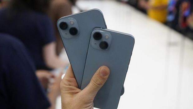 Pengunjungmemegang model iPhone 14 baru di acara Apple di kampus kantor pusat Apple di Cupertino, California, Rabu (7/9/2022). (AP Photo/Jeff Chiu)