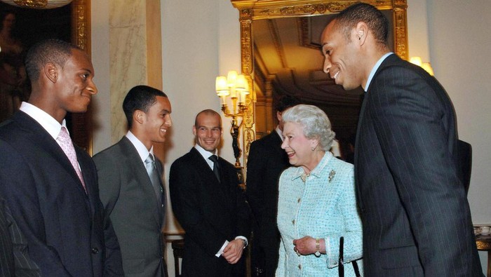 London, UNITED KINGDOM: Britains Queen Elizabeth II meets with Arsenal football team members (from L) Justin Hoyte, Theo Walcott, Freddie Ljungberg and captain Thierry Henry (R) at Buckingham Palace, 15 February 2007. Queen Elizabeth II hosted Arsenal footballers in a teatime fixture at Buckingham Palace 15 February to make up for her having to forfeit opening their new ground last November because of a bad back. The 80-year-old monarch invited the English Premiership clubs players and staff to the palace for a tour of the State Apartments before their gathering in the Bow Room. Gunners captain Thierry Henry, the clubs record goal scorer, swapped his red and white kit for a smart dark suit and tie for the occasion.   AFP PHOTO / PA / Fiona Hanson (Photo credit should read FIONA HANSON/AFP via Getty Images)